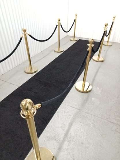 Black carpet runner with black ropes and gold stanchions